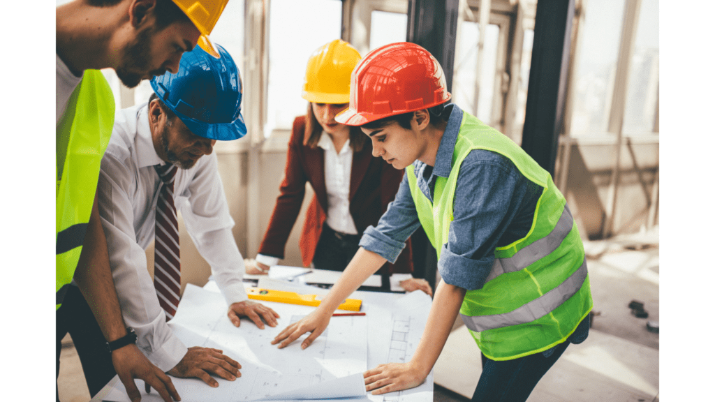 A group of people in hard hats looking at plans.